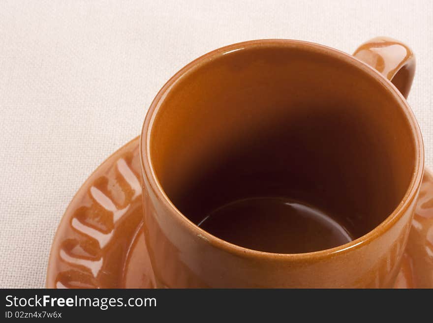 Empty ceramic cup with a saucer on a white background.