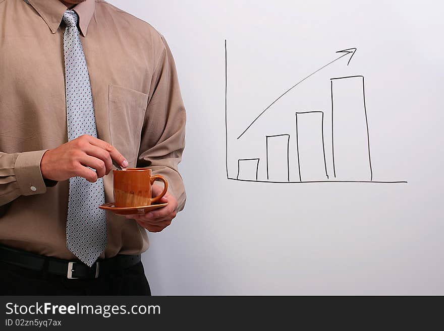 Man in a shirt and a tie holding a plate and a cup while standing next to a drawing of a bar graph. Man in a shirt and a tie holding a plate and a cup while standing next to a drawing of a bar graph.