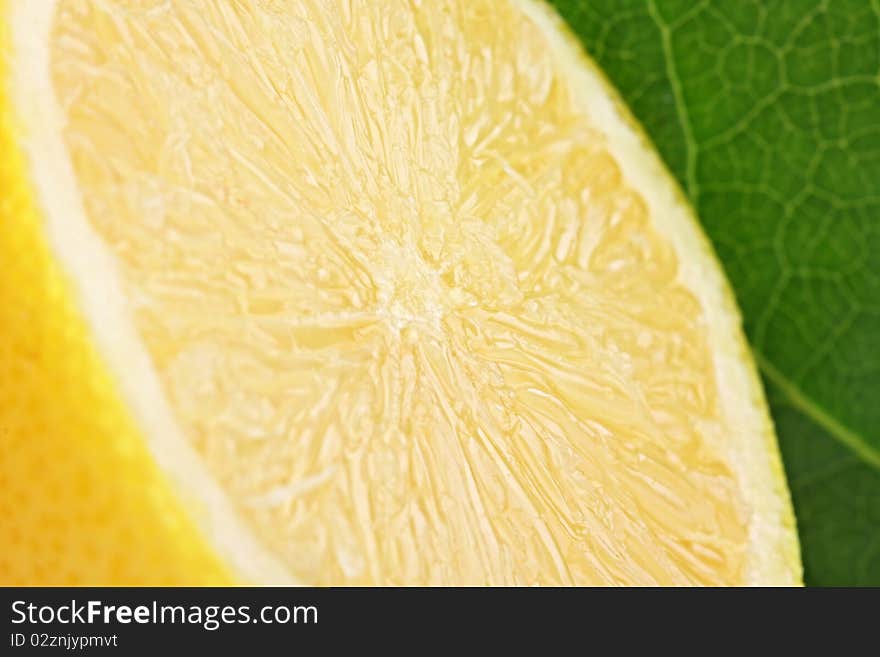 A fresh cutted lemon with a green leaf in backgrond. A fresh cutted lemon with a green leaf in backgrond.