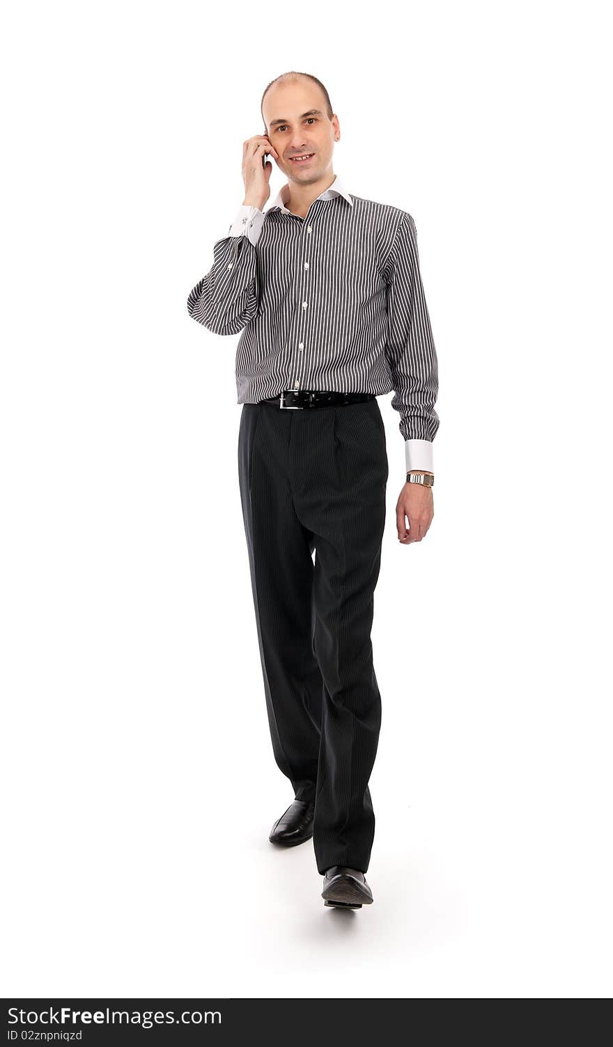 Portrait of happy businessman talking on mobile phone while walking - White background