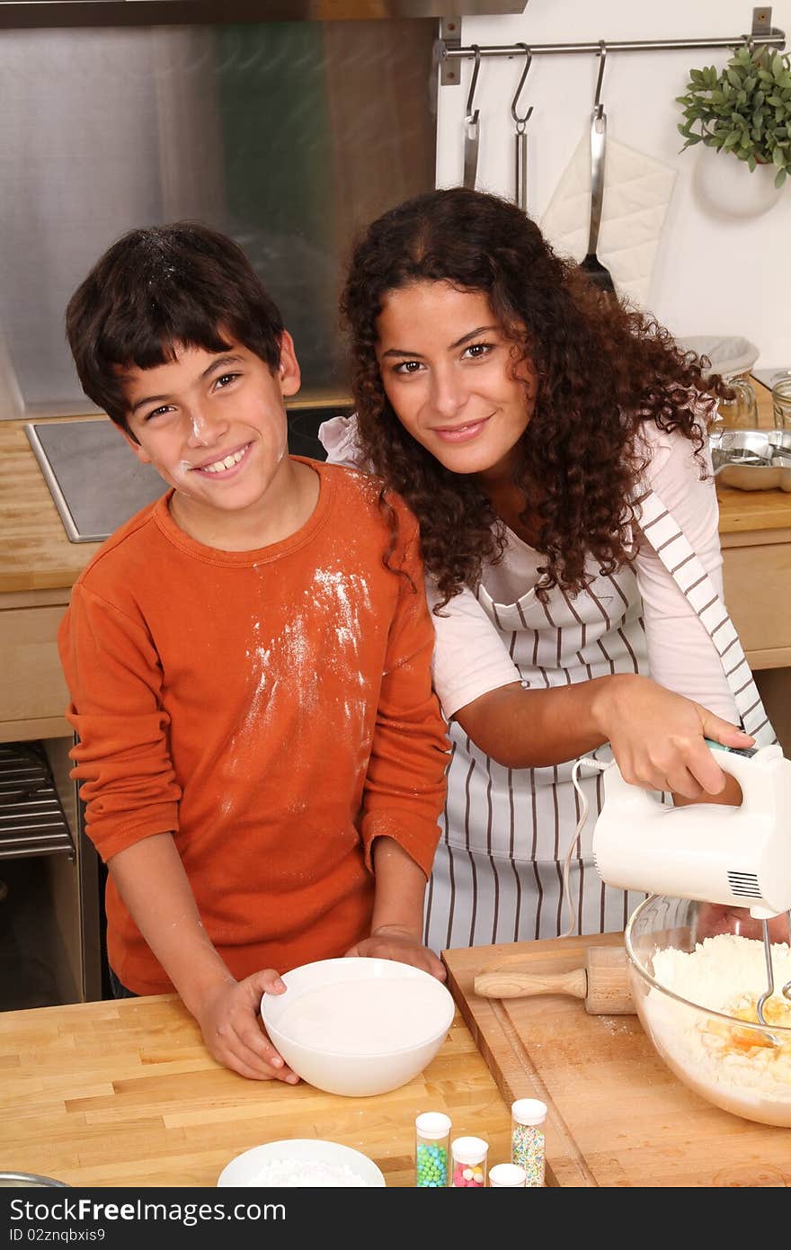 Beautiful Mother with her boy is baking some christmas cookies. Beautiful Mother with her boy is baking some christmas cookies