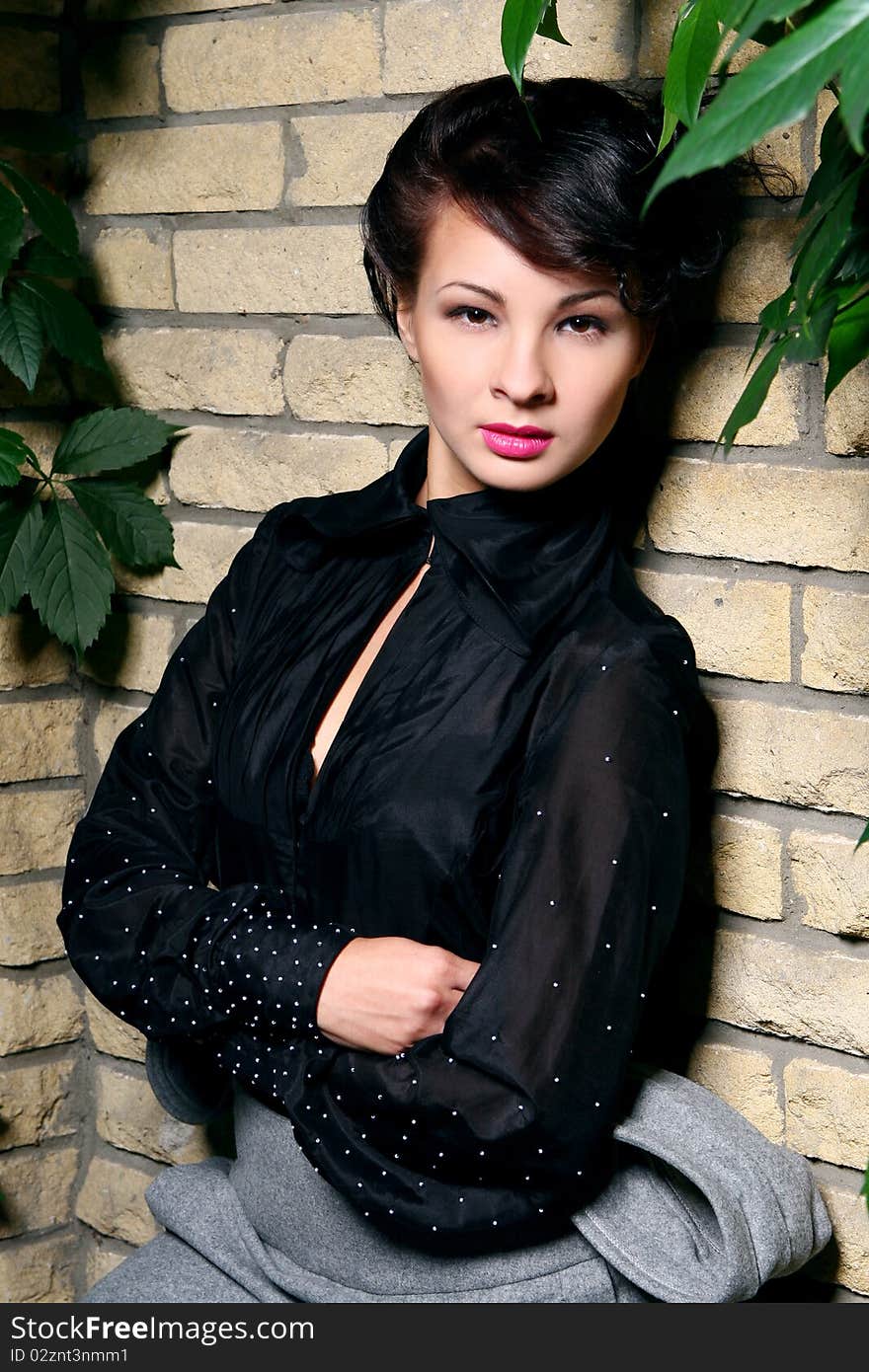 Young and attractive lady beside with brick wall