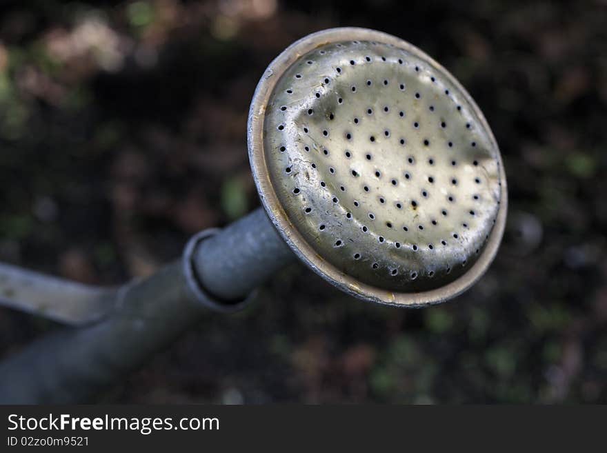 A dented old watering can. A dented old watering can