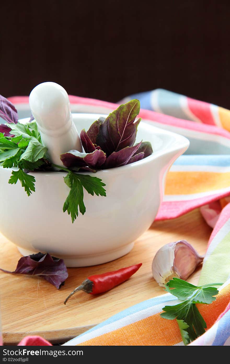 Mortar and pestle with herbs on a wooden board