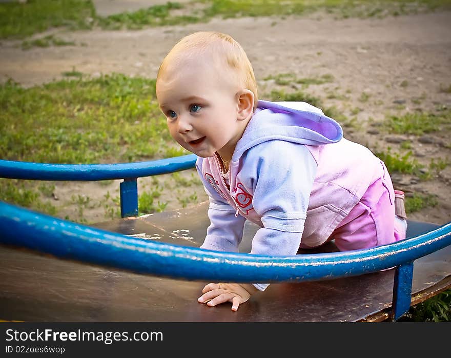 Beautiful Baby Girl Climbing A Slide In Playground