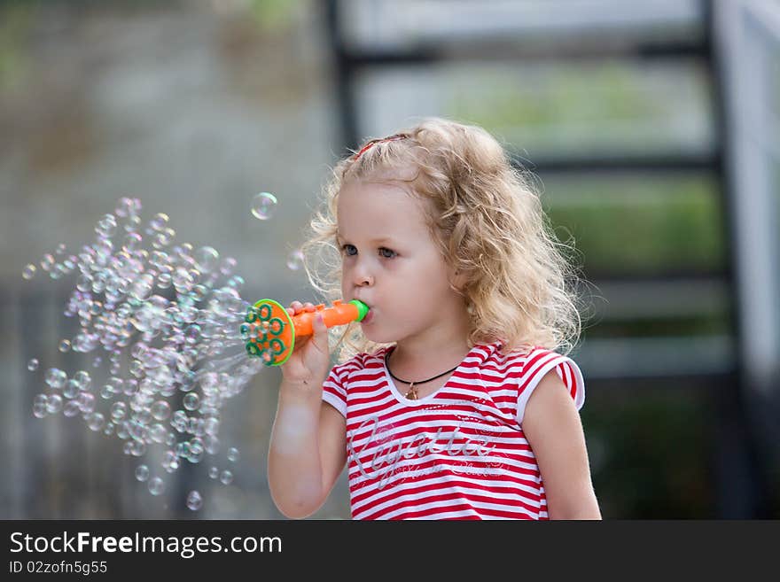 Young girl blowing bubbles.