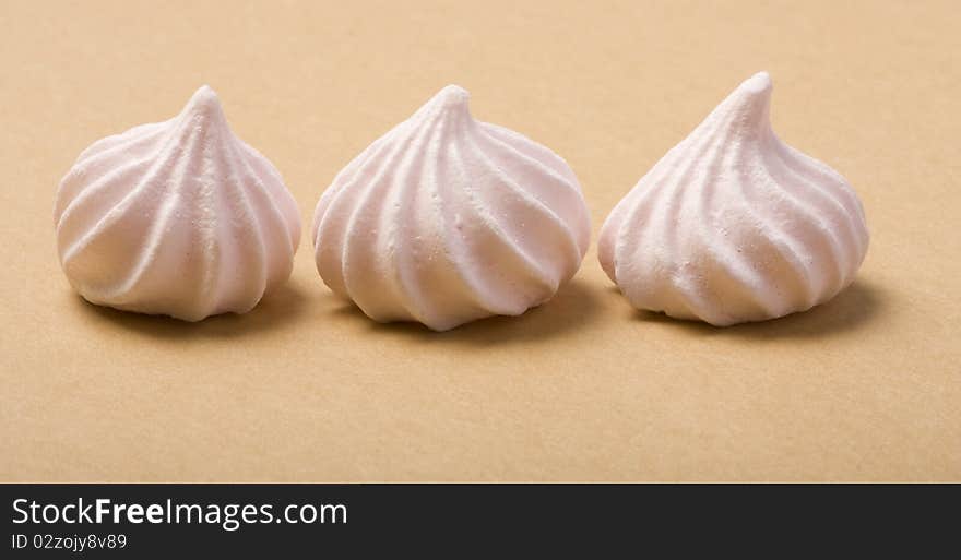 Three Pink Merinque cakes on the cardboard background.