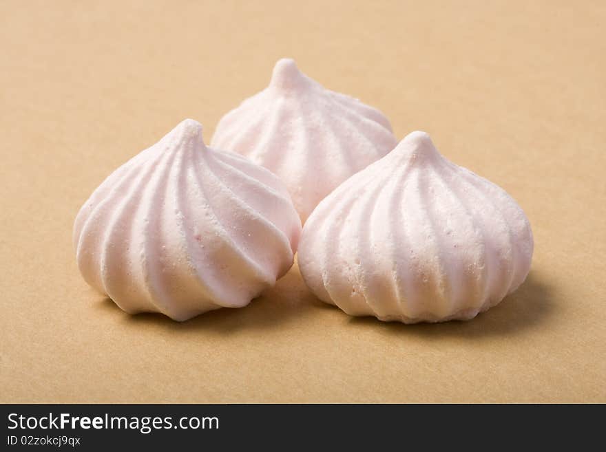 Three Pink Merinque cakes on the cardboard background. Shallow depth of field.