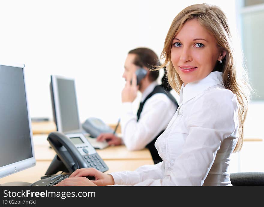 A young girl in his office at his workplace works at the computer