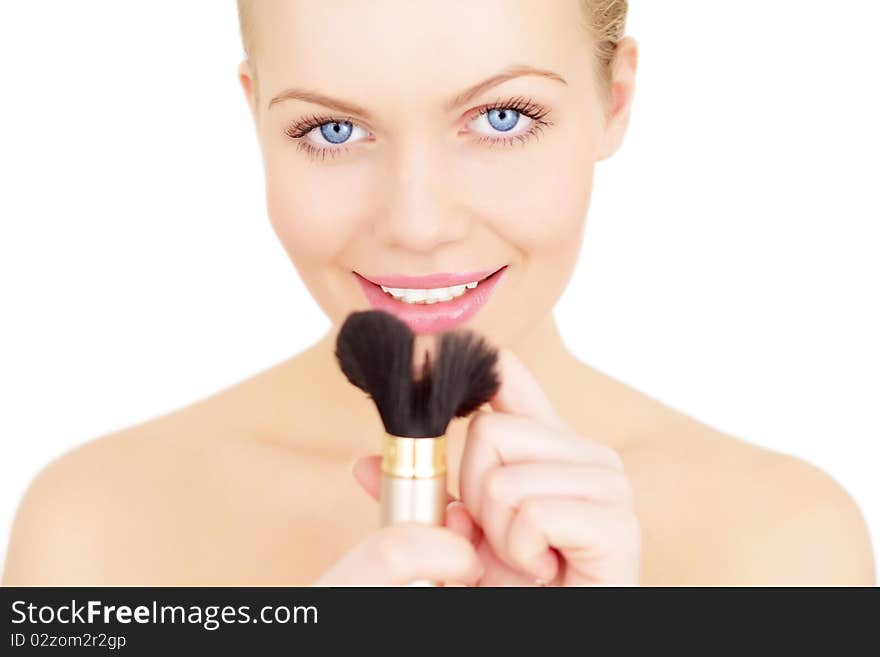 Young woman applying blusher isolated on a white background