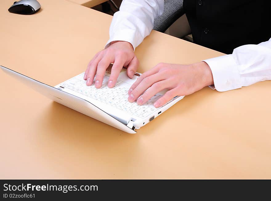 Hands of a young man working on the computer in the office.