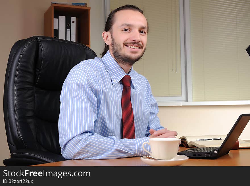 A young business man working in an office at his workplace.