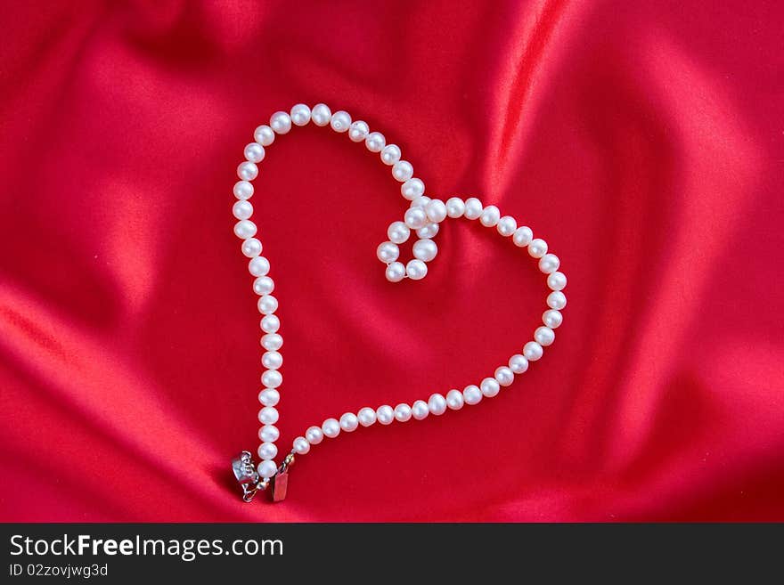 Luxury white Pearl's necklace on red background. Luxury white Pearl's necklace on red background