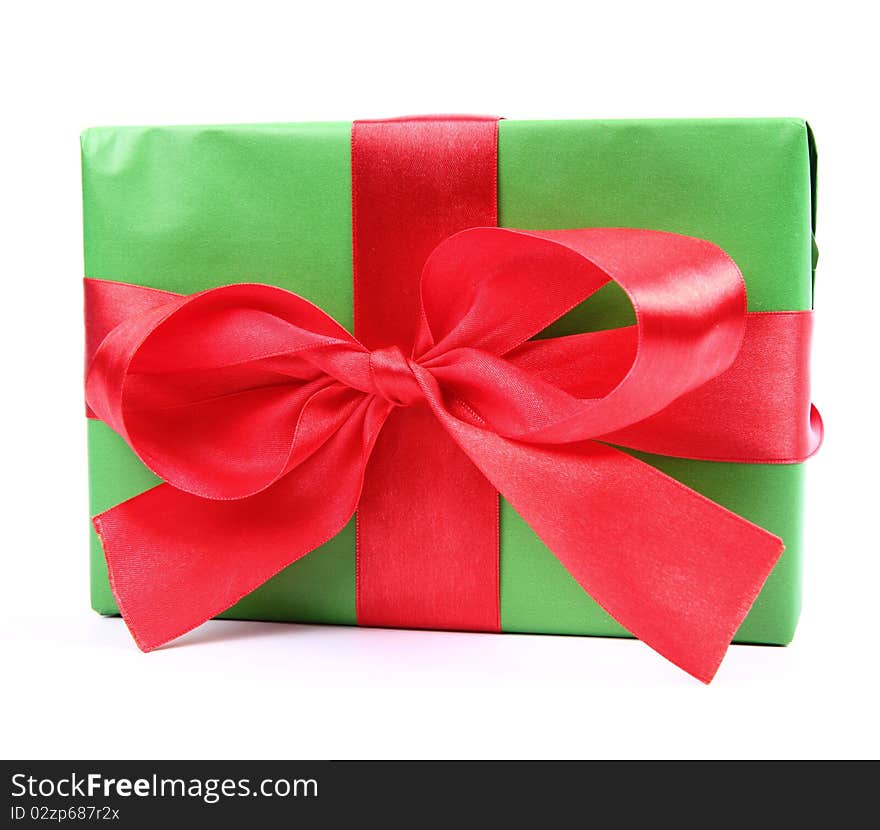 Gift in green wrapping with a red bow on white background