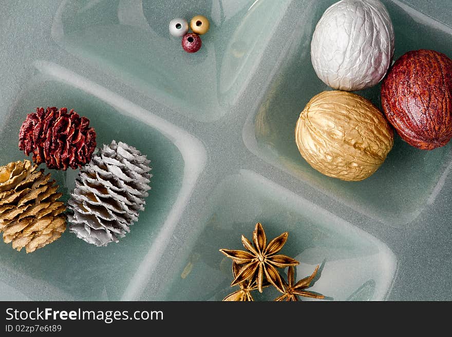 Christmas ornaments, golden and silver walnut and pine cone on glass plate. Christmas ornaments, golden and silver walnut and pine cone on glass plate.