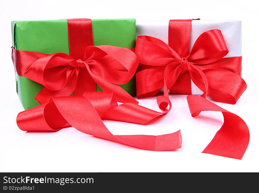 Gifts in green and silver wrapping with red bows on white background