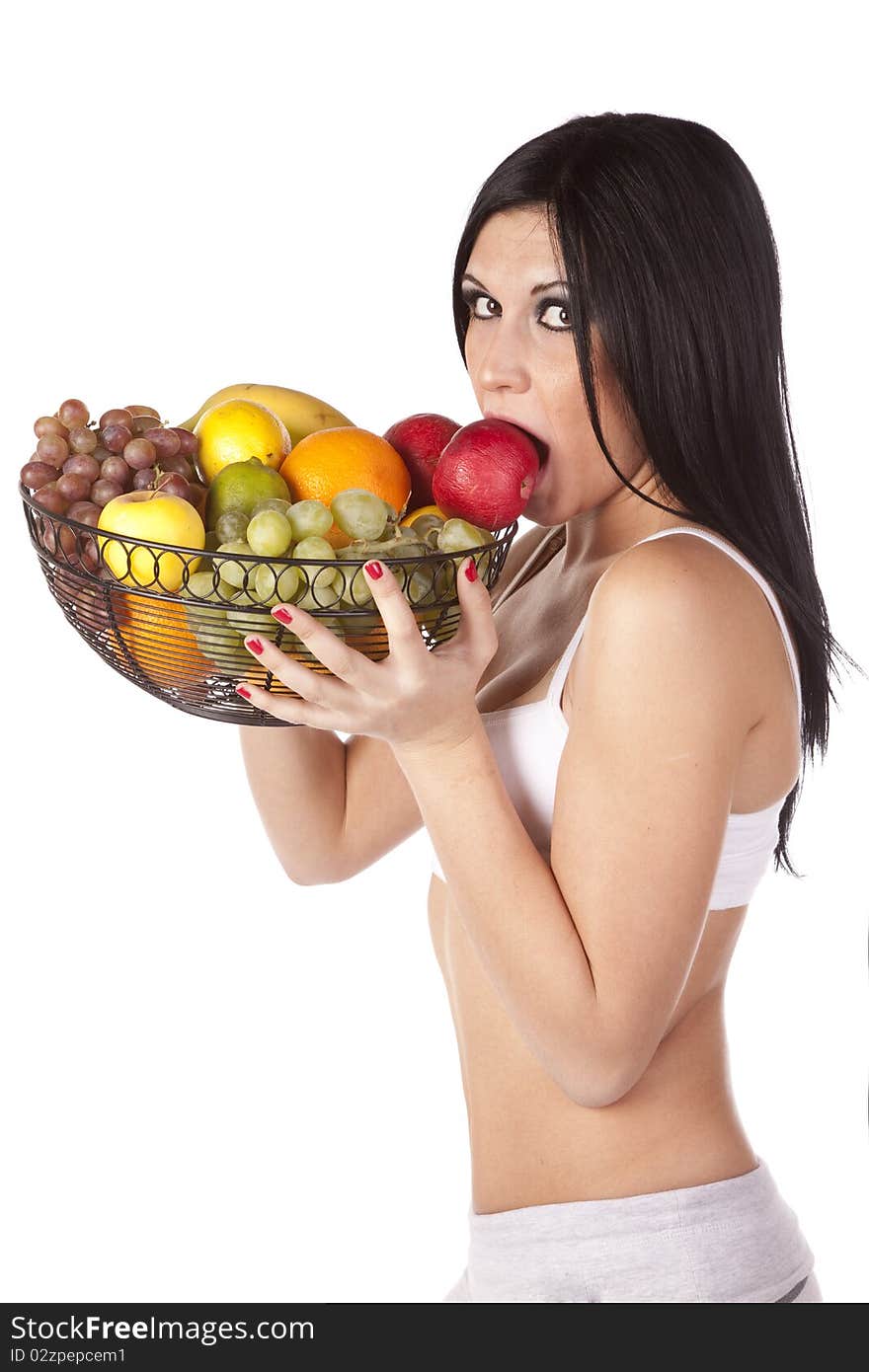 Woman eating apple in fruit basket