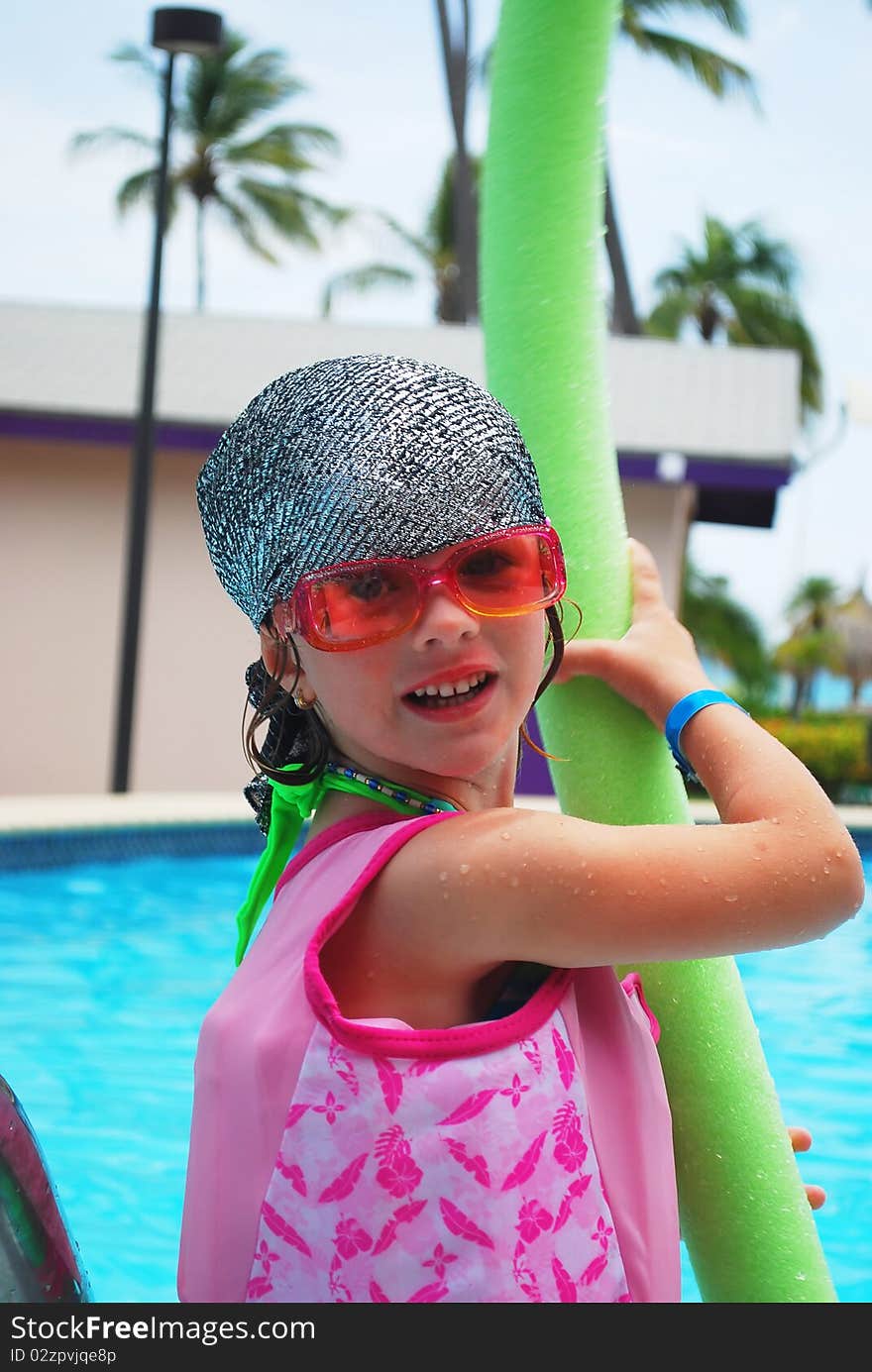 Happy little girl ready  to swim with pool noodle in tropical resort. Happy little girl ready  to swim with pool noodle in tropical resort.