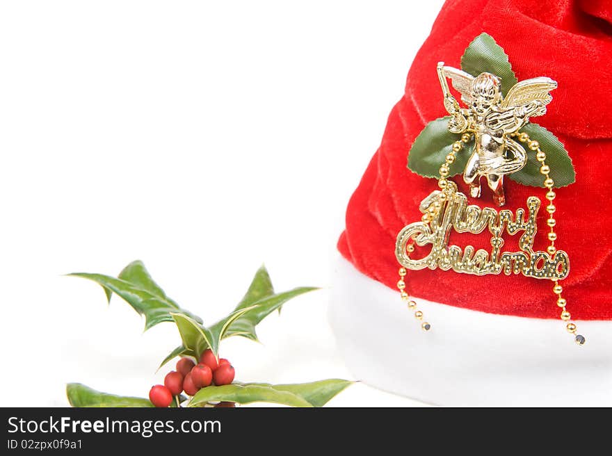 Red santa claus hat and holly berry isolated on white background