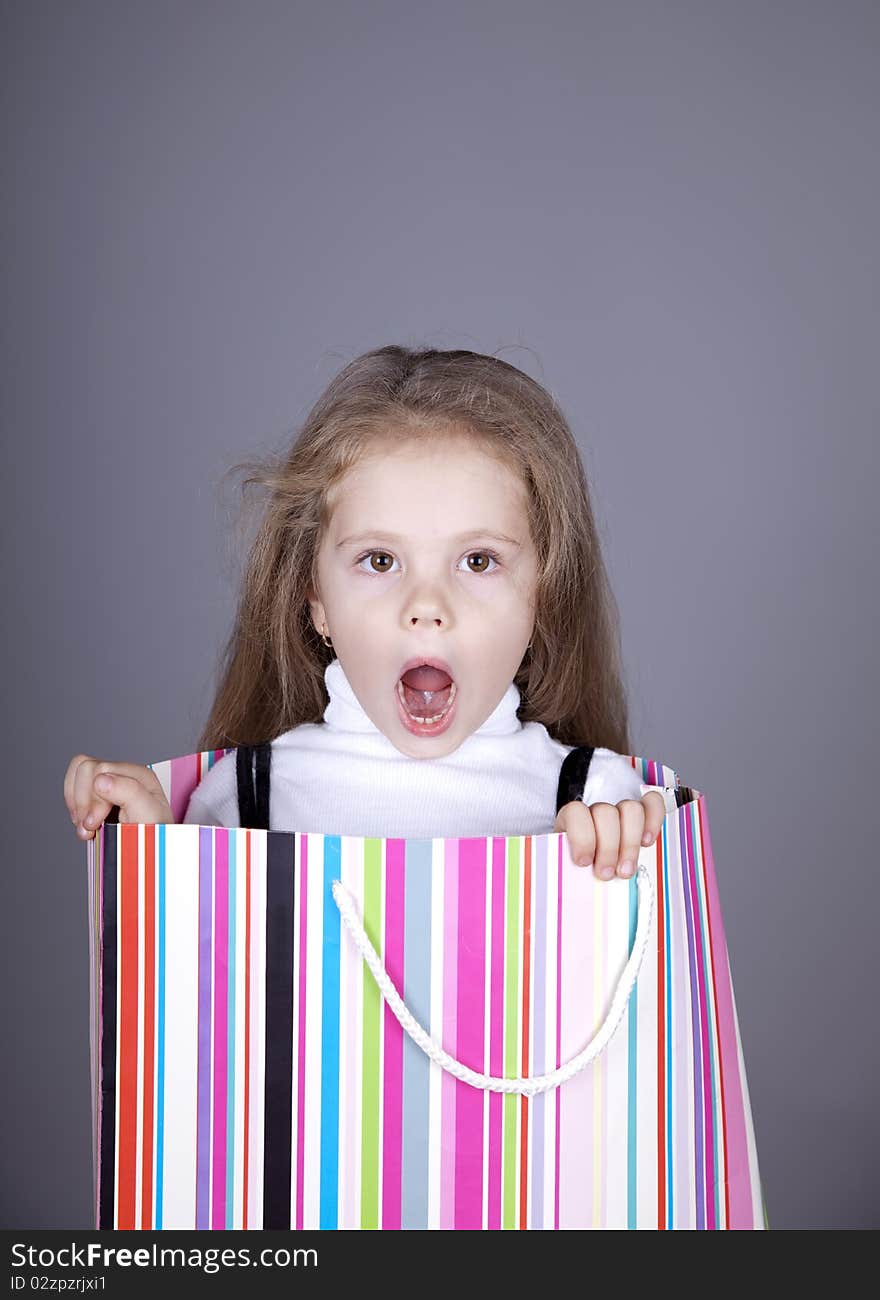 Little girl in shopping box. Studio shot.