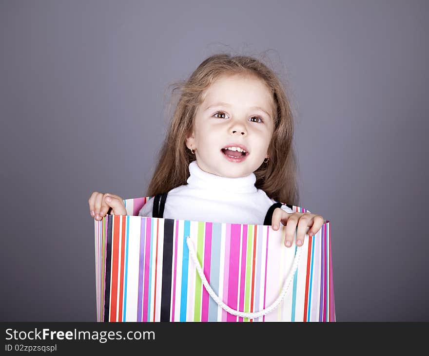 Little girl in shopping box. Studio shot.