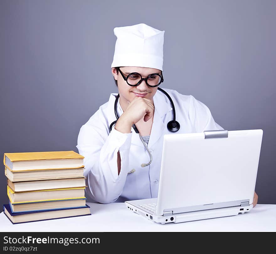 Young doctor with books and computer.