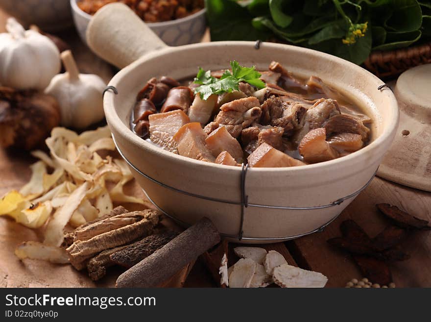 A Malaysian herbal pork dish with herbs as background. A Malaysian herbal pork dish with herbs as background