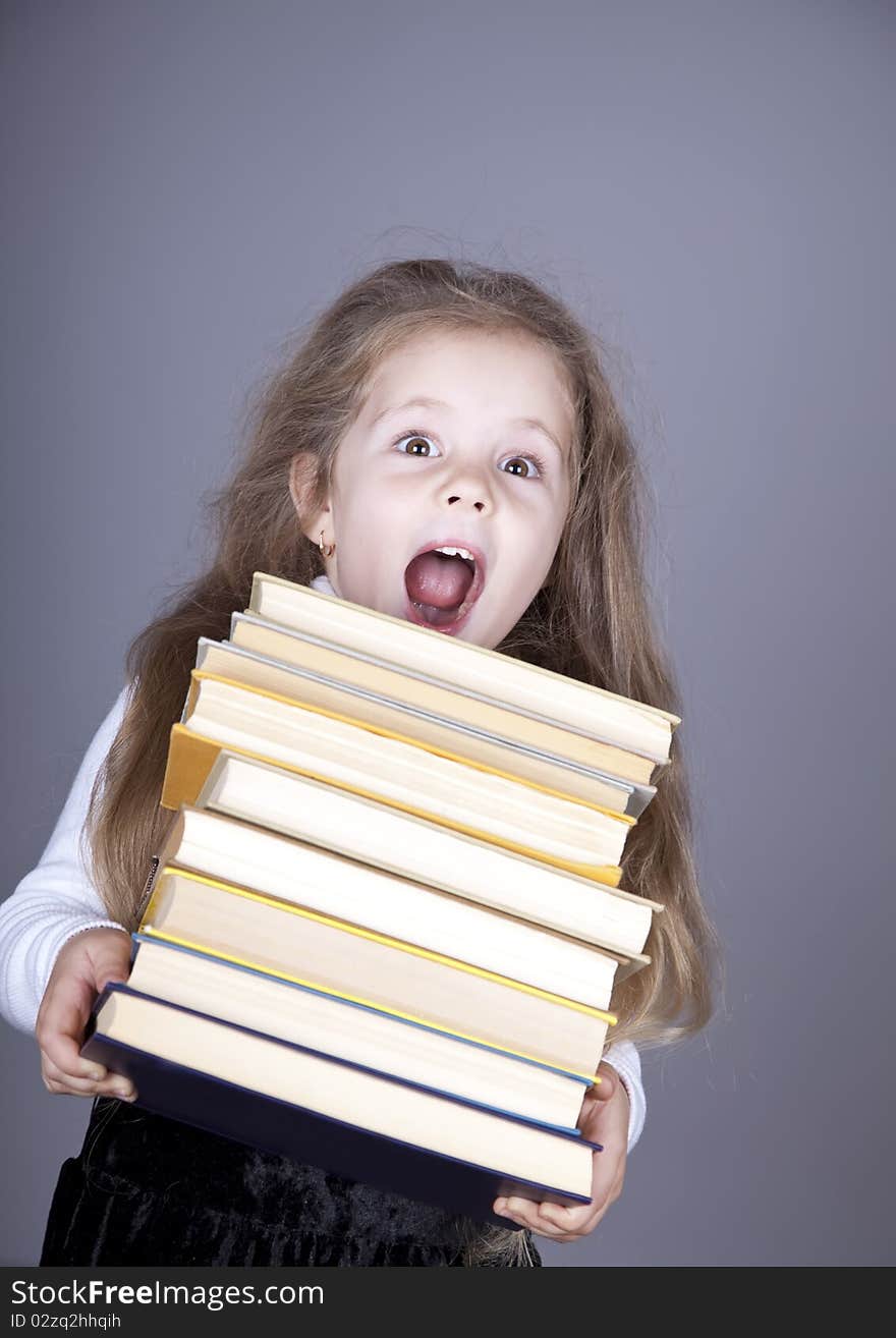 Little schoolgirl with books.  Studio shot.