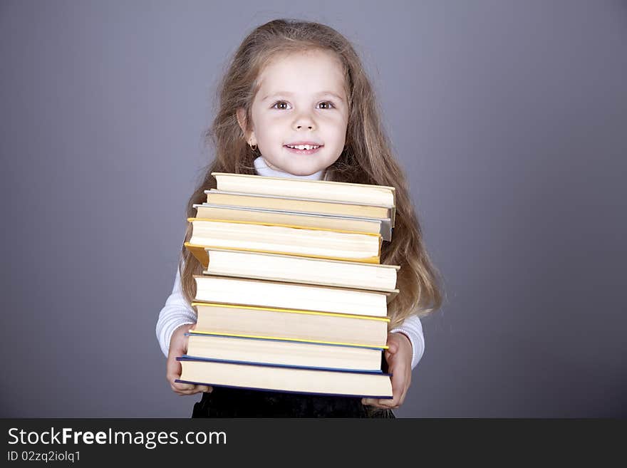 Little schoolgirl with books. Studio shot.