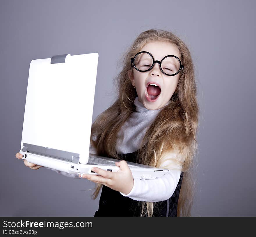 Young little girl in glasses with notebook. Studio shot.