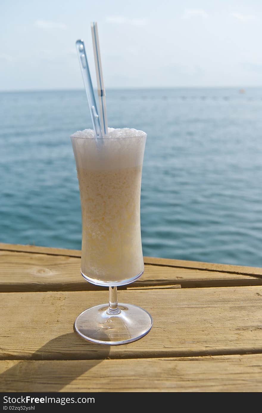 Milk cocktail with rum, cream of coconut and pineapple juice near the sea. Milk cocktail with rum, cream of coconut and pineapple juice near the sea