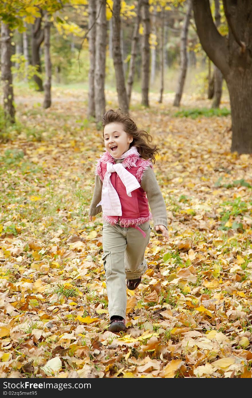 Cute running girl in autumn park.