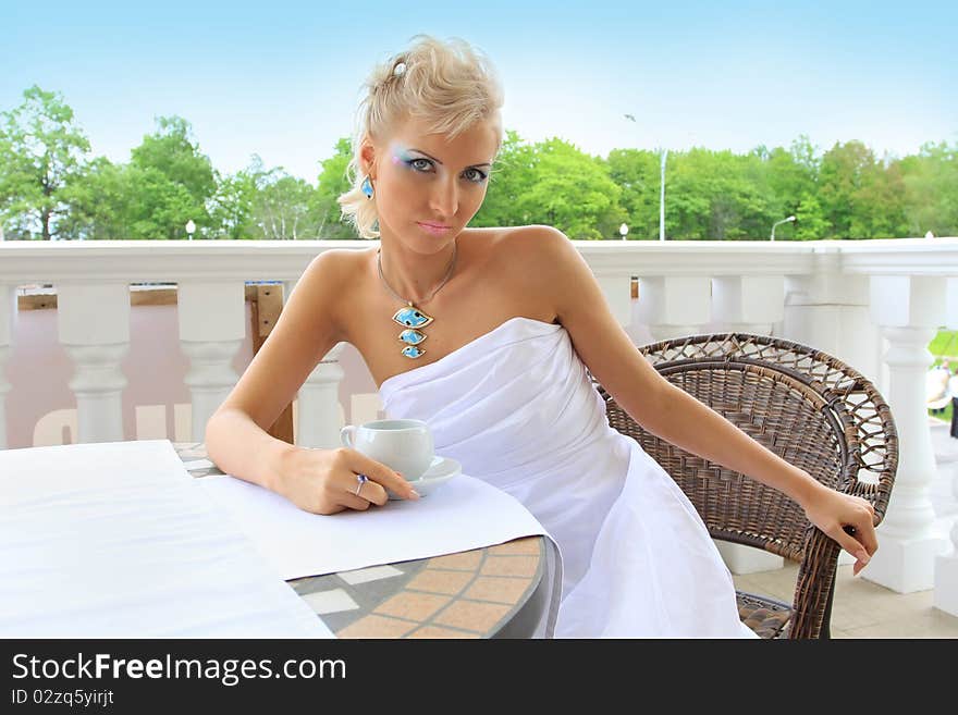 Stylish fashion model sitting in a restaurant outdoors