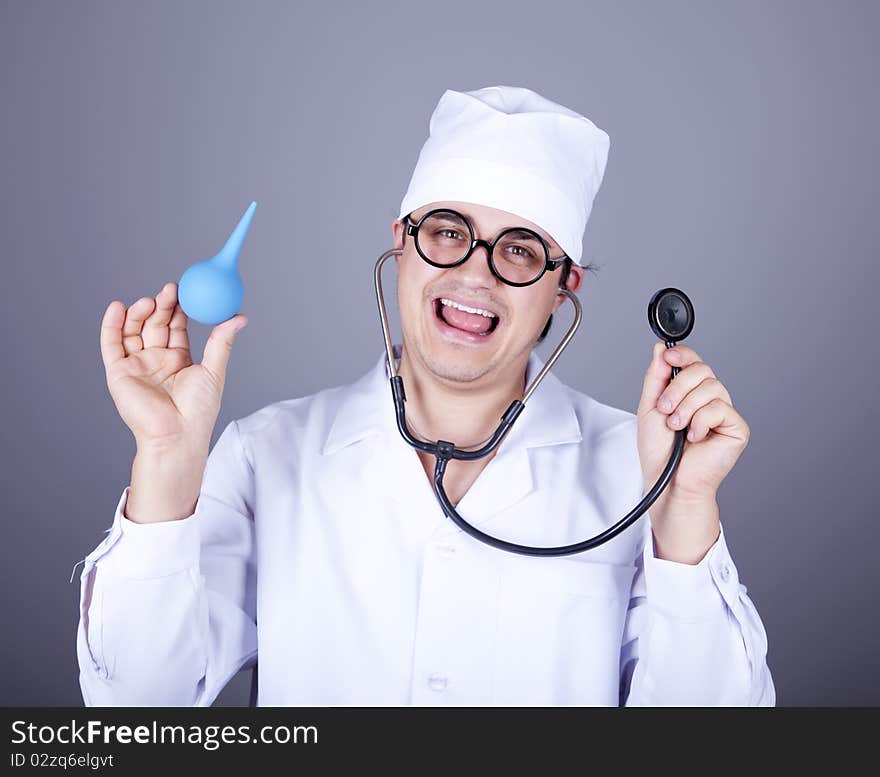 Crazy doctor with a stethoscope and enema. Studio shot.