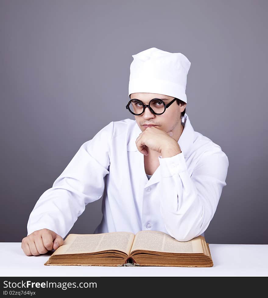 Young male doctor studying medical book. Studio shot.