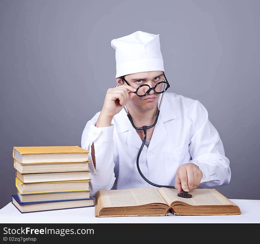 Young male doctor studying medical books. Studio shot.