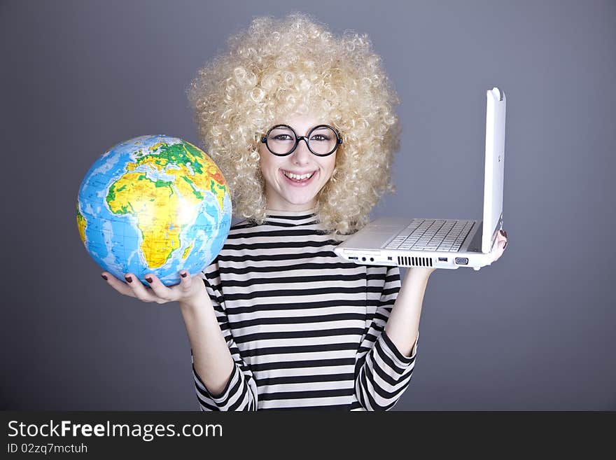 Funny girl in glasses keeping notebook and globe. Studio shot.