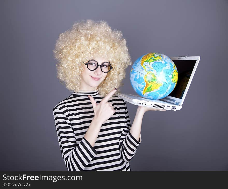 Funny girl in glasses keeping notebook and globe. Studio shot.