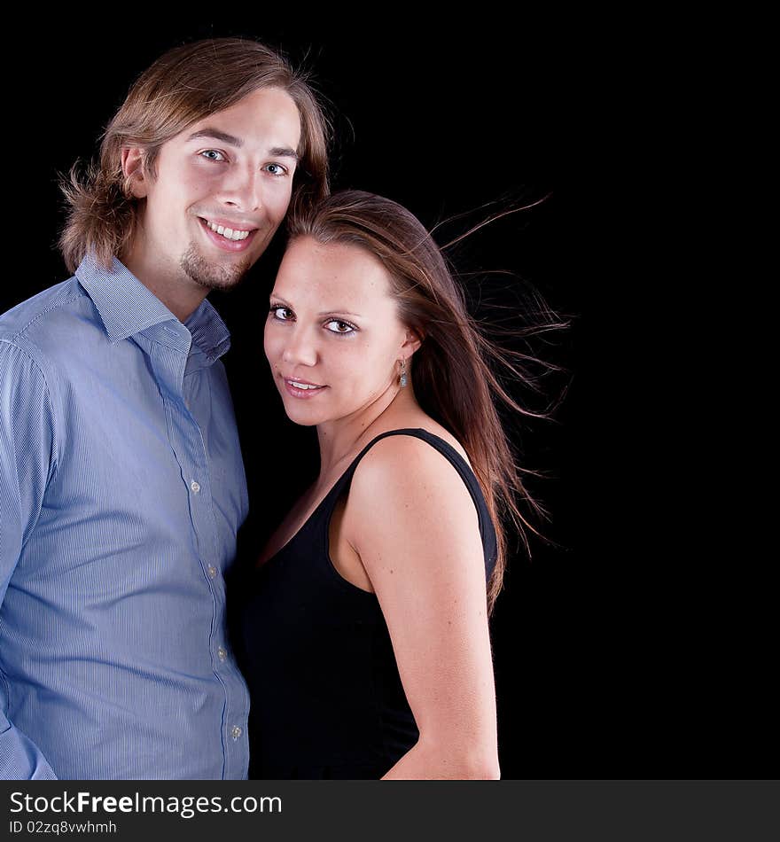 Young cute couple with long hair over black background. Young cute couple with long hair over black background.