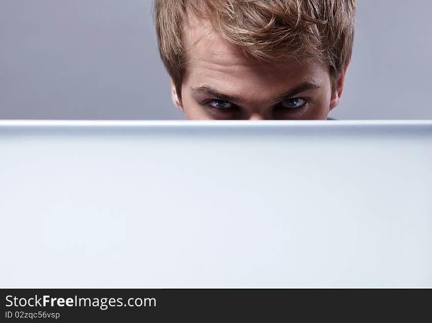 Young attractive man looks out for the laptop. Young attractive man looks out for the laptop