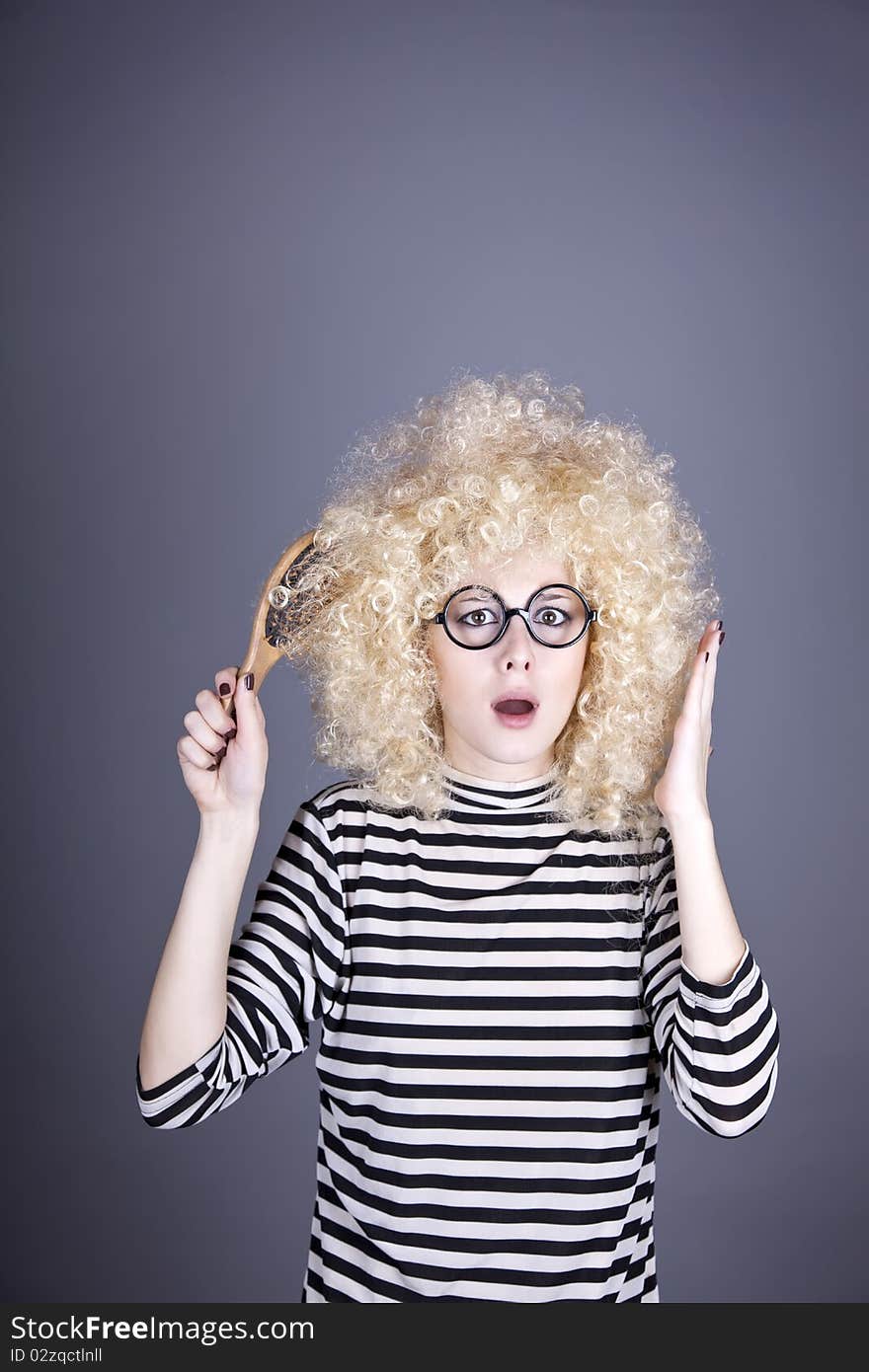 Surprised girl with comb. Studio shot.