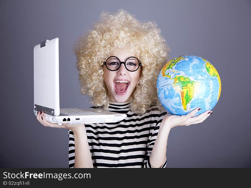 Funny girl in glasses keeping notebook and globe. Studio shot.