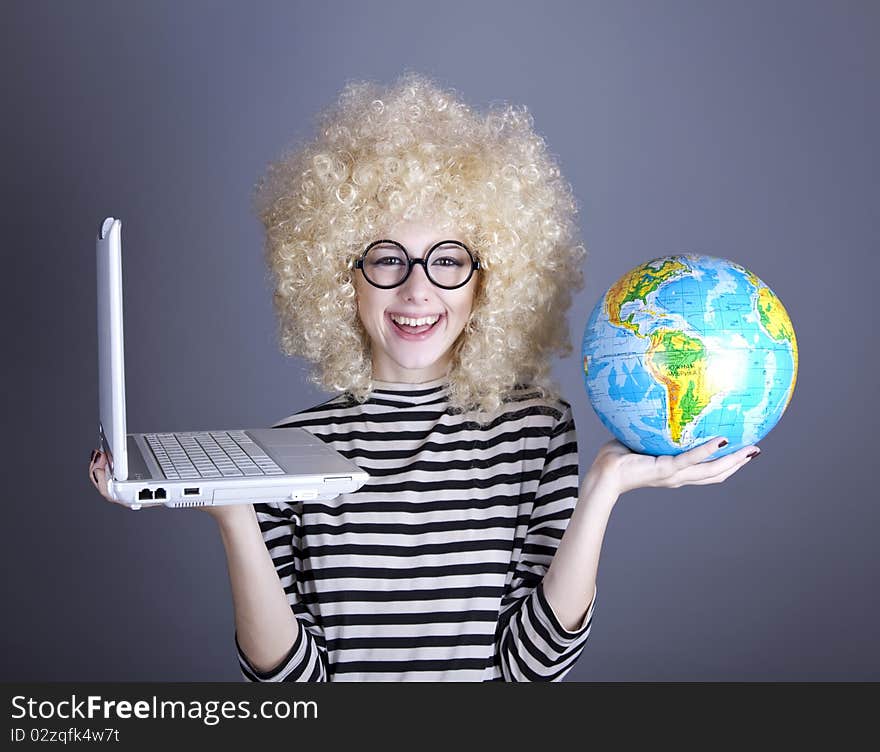 Funny girl in glasses keeping notebook and globe. Studio shot.