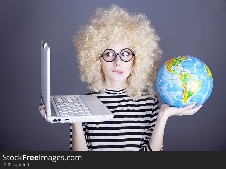 Funny girl in glasses keeping notebook and globe. Studio shot.