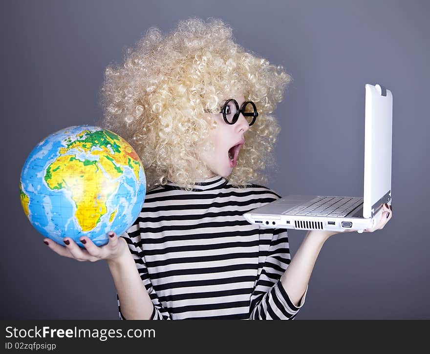 Funny girl in glasses keeping notebook and globe. Studio shot.