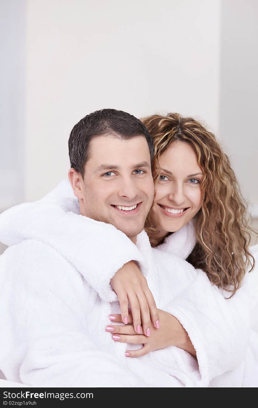 Young couple embracing in robes. Young couple embracing in robes