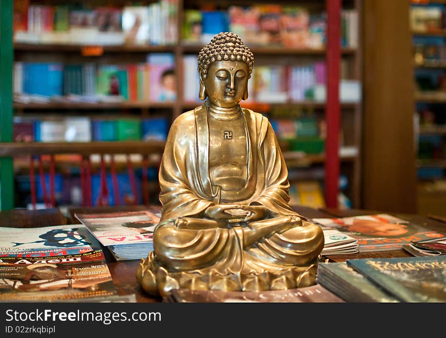 A golden Buddha statuette among yoga magazines