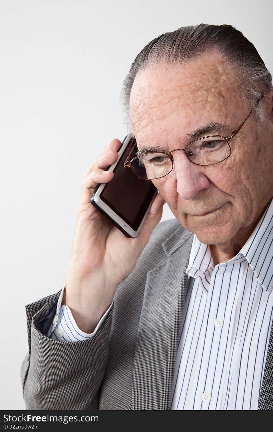 Mature man wearing coat and talking on cell phone. Mature man wearing coat and talking on cell phone.