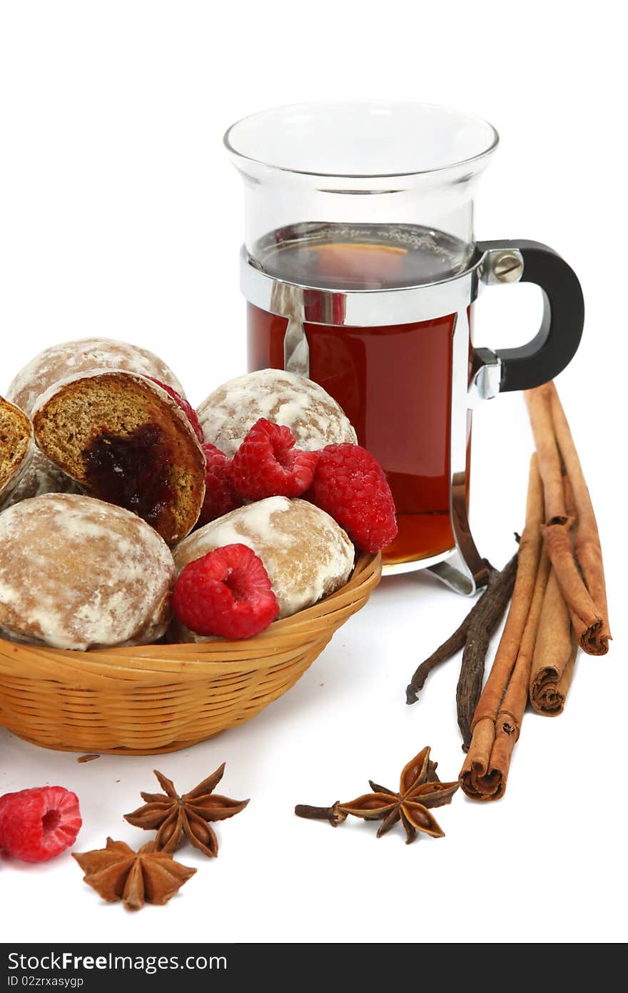 Spicy winter hot drink with raspberry, spices and spice-cakes on a white background. Spicy winter hot drink with raspberry, spices and spice-cakes on a white background.