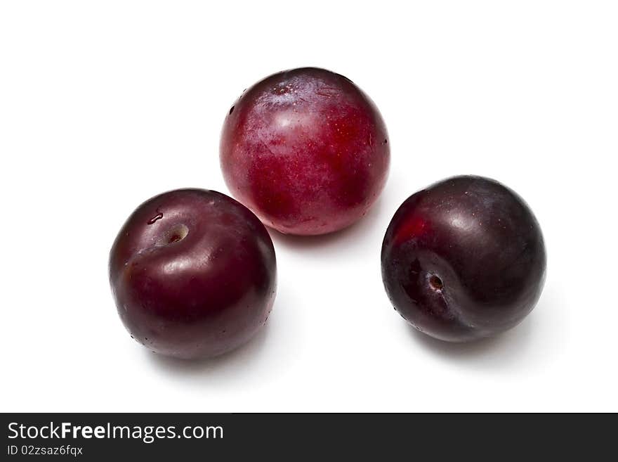 Three red plums isolated on white background